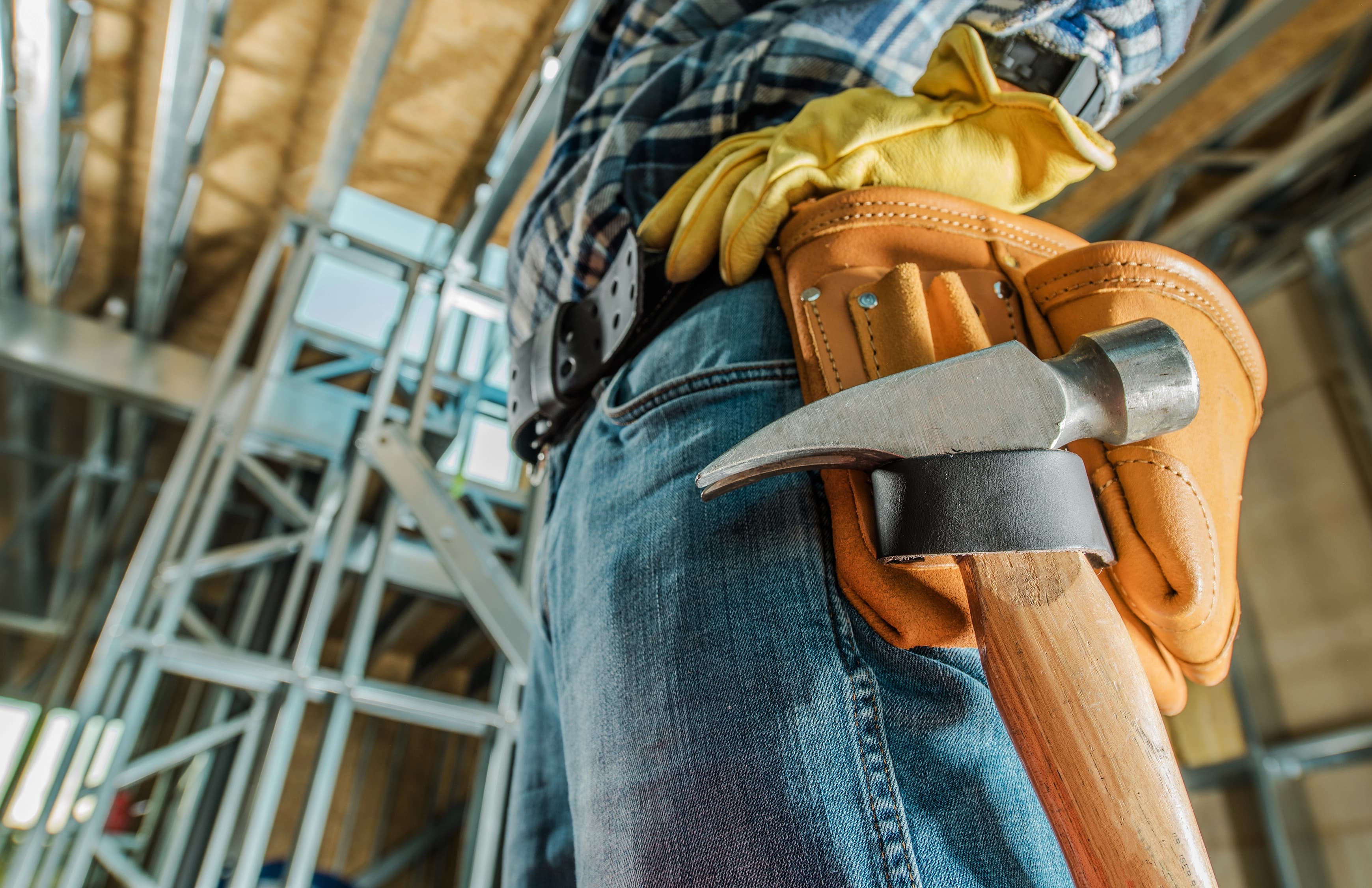 Construction contractor wearing a tool belt on a job site, representing commercial insurance coverage for Texas businesses.